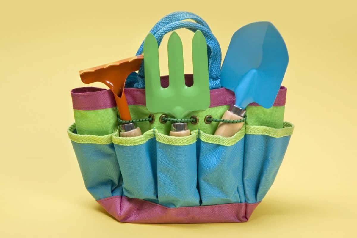 Colorful children's garden tools in a fabric tote