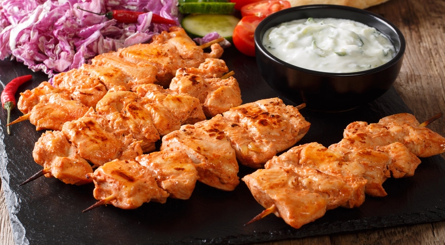 Chicken kabaobs on board ith yogurt sauce