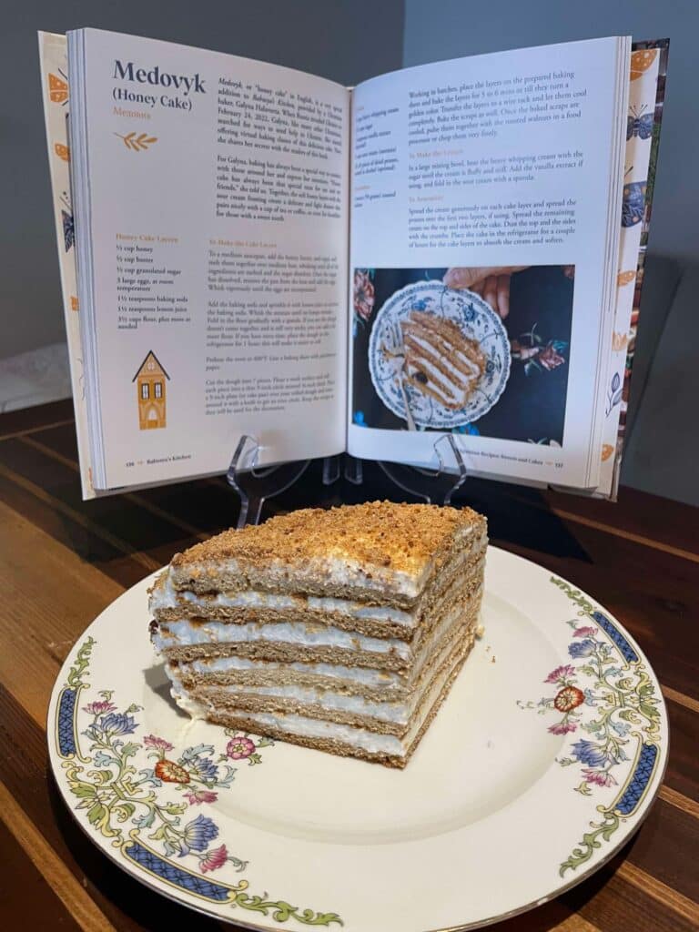 Babusya's Cookbook open to Honey Cake recipe with a slice of the cake