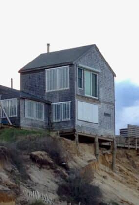 House on the edge of a sand dune, about to fall off.