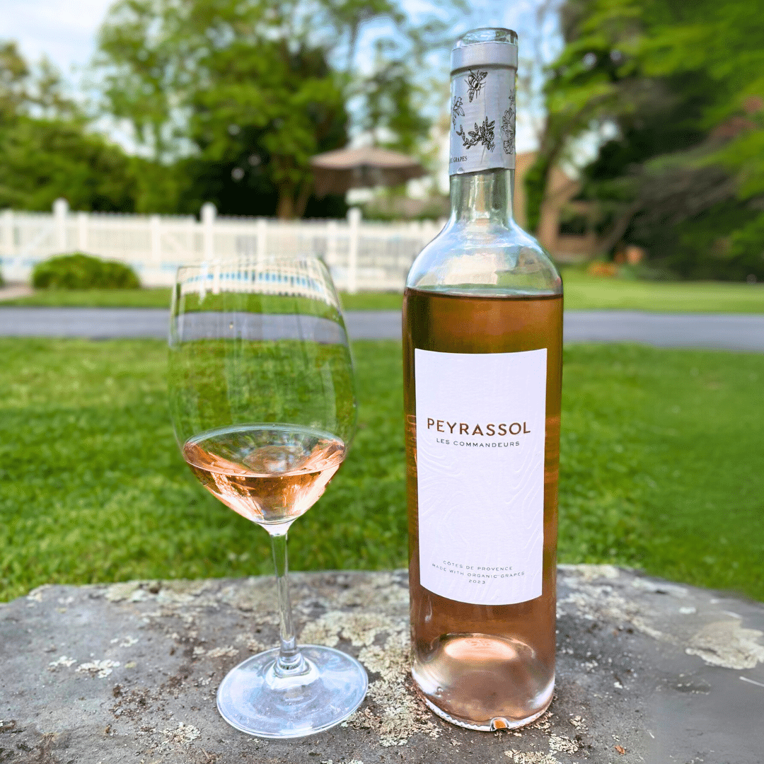 Glass and bottle of rosé on a table outside