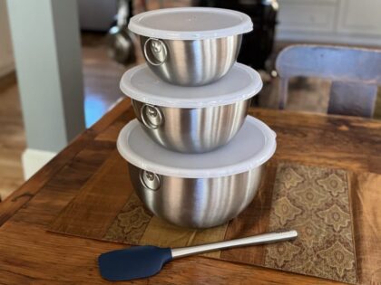 Tovolo nesting bowls with lids on a table with blue spatula
