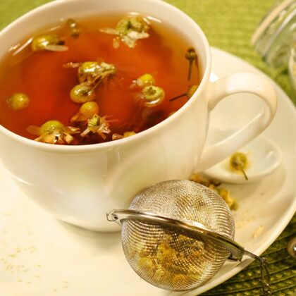 A cup of chamomile tea with a tea ball