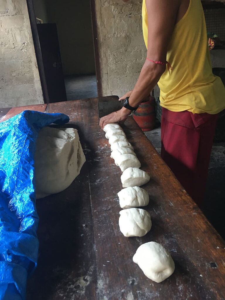 Hands cutting a strip of dough