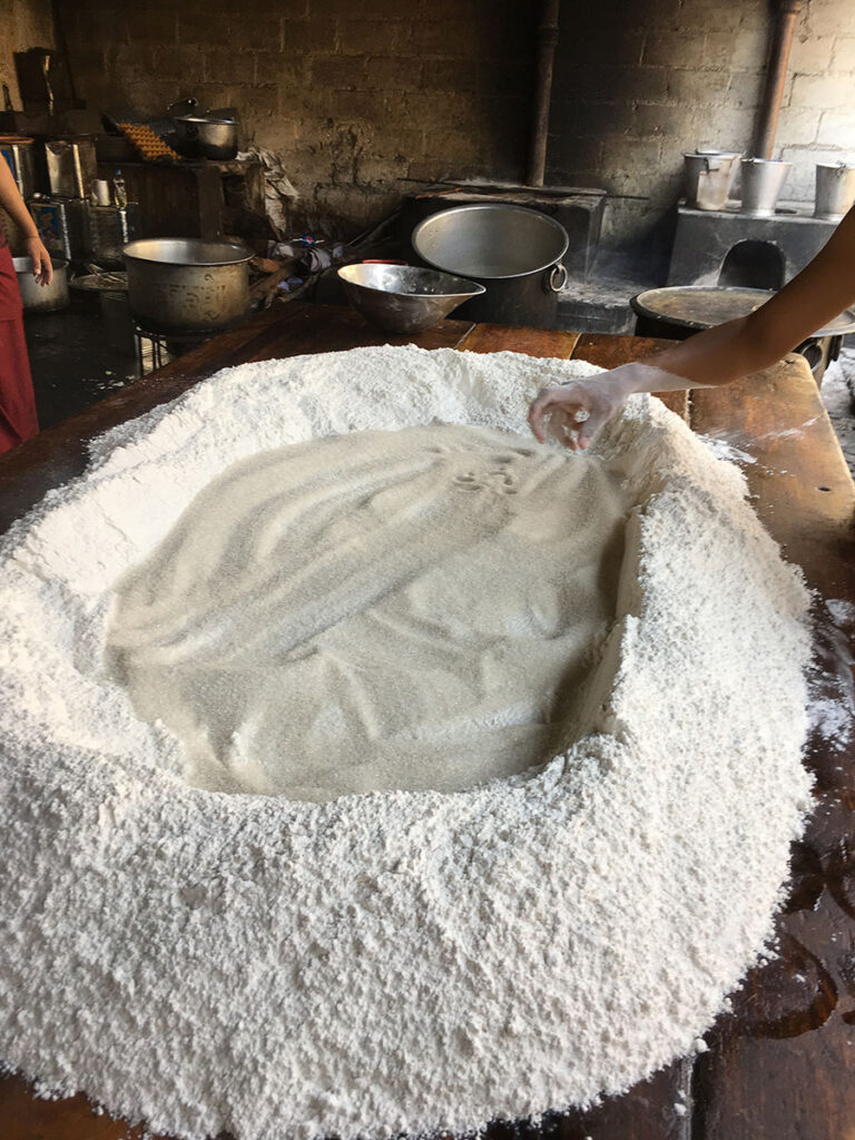 Large mound of white flour on wooden table