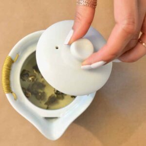 Gaiwan lid covering tea for steeping process.