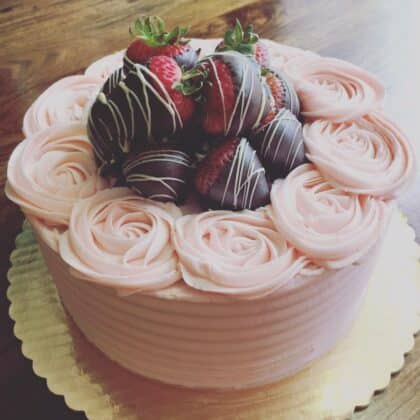 Gluten-free strawberry cream cake topped with chocolate dipped strawberries by Tony Lakroix