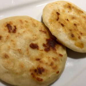 A perfectly grilled pupusa displayed on a plate