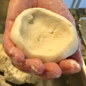 Hand presenting a hollowed dough ball