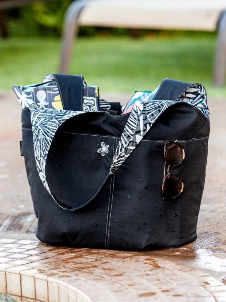 Black cargo tote with a patterned scarf and sunglasses. From the Ripskirt collection labeled 'WEARABLES'.