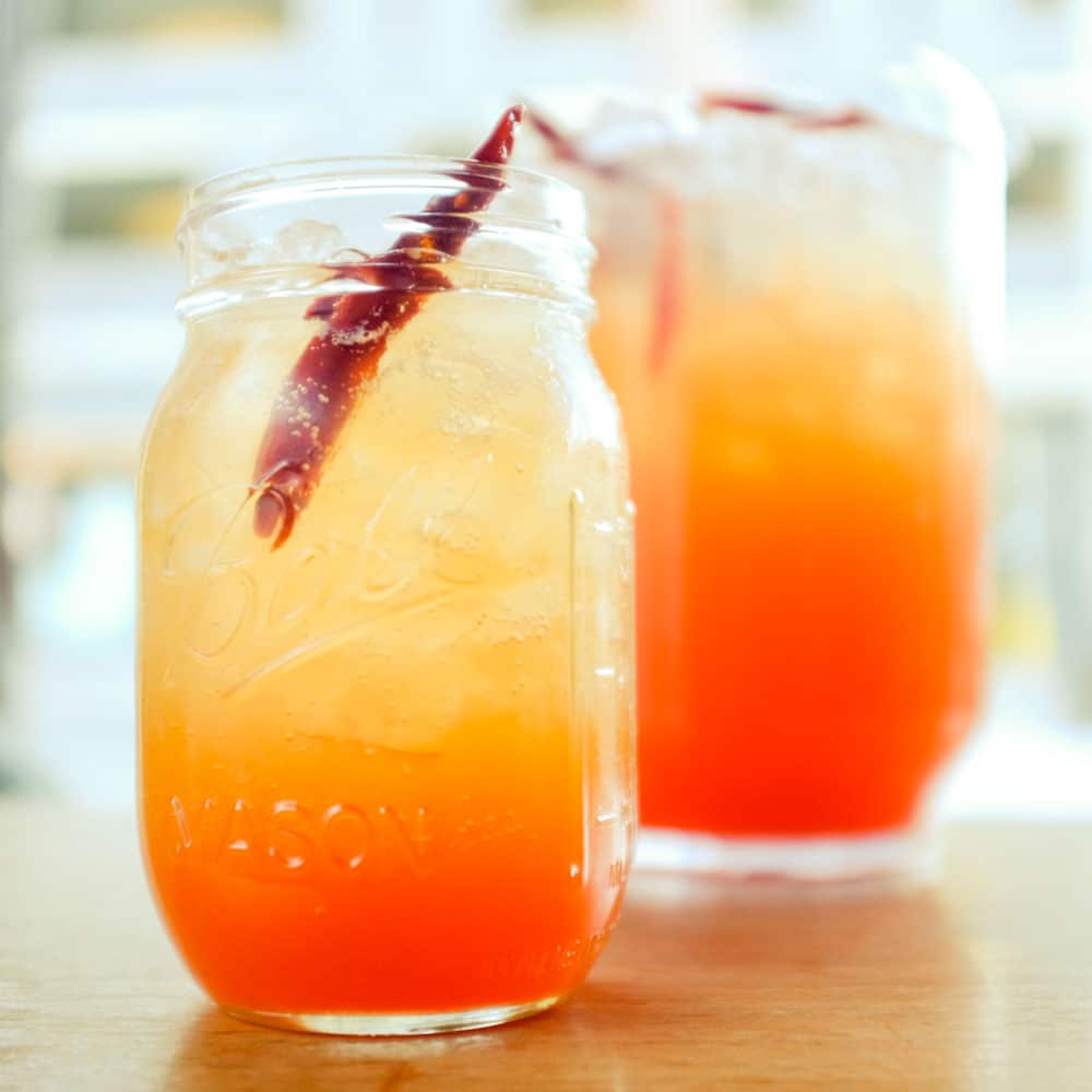 orange and yellow drink in mason jar
