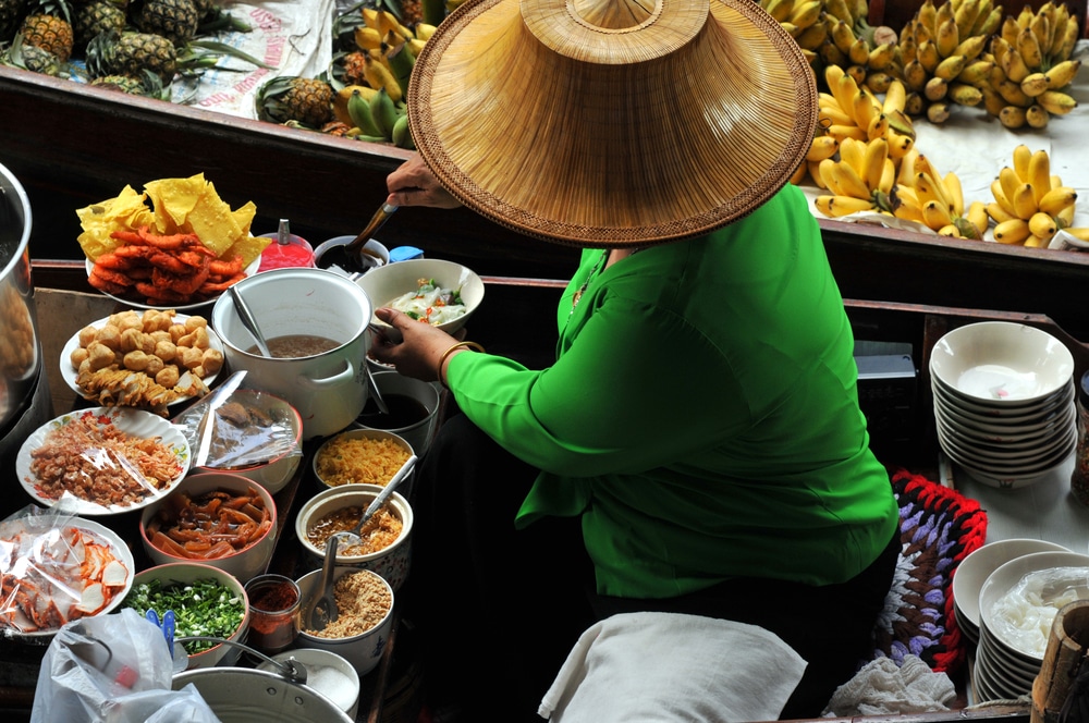 Close up of man hand grated coconut using an electric coconut grater in  Thailand Stock Photo