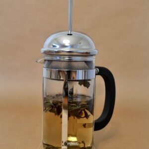 White tea leaves unfurling in a French press.