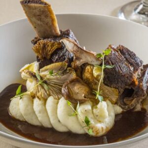 Succulent wine braised short ribs served over mashed potatoes with mushrooms and sauce.